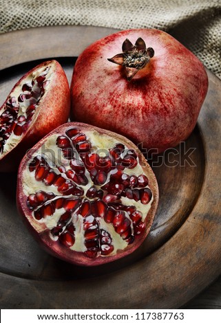 Pomegranate in rustic wooden plate