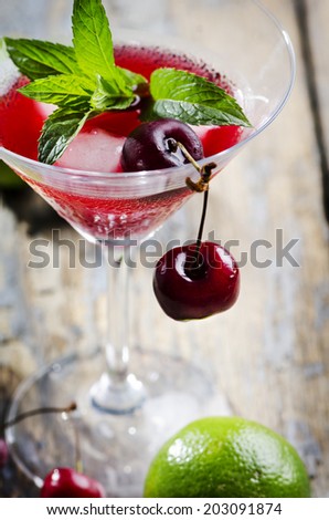Cherry cocktail in martini glass on rustic table