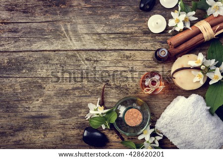 Essential oils with jasmine, cinnamon and vanilla on rustic wooden table, retro style image.