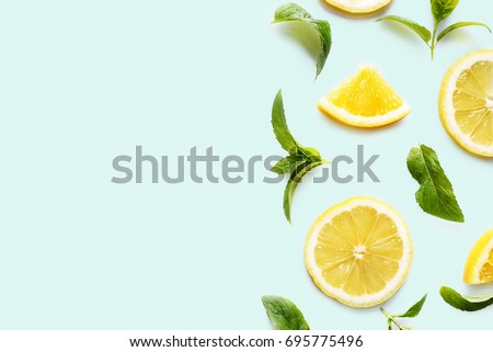 Top view of citrus slices and mint herbs frame on retro mint background with copyspace