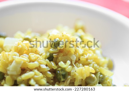 Yellow risotto. Recipe: rice, turmeric, ginger, peas and leek. This is a vegan dish and all ingredients are organic food./ Macro of Risotto with turmeric, ginger, peas and leek