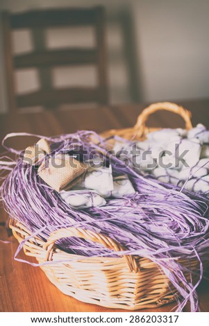 Preparation for wedding favors: confetti, jute sachet and purple raffia./Basket with purple raffia,confetti and jute sachet