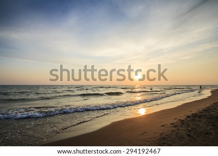 Sunset on the beach during the summer, the sun is going down over the sea and the beach is almost deserted/Sunset on the beach