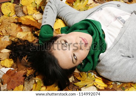 Young woman lying on the leaves in the park