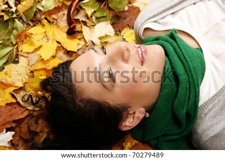 Young female lying on the leaves in the park