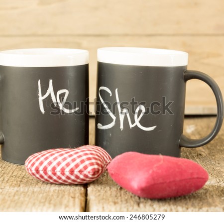 Cup with words He and She written with chalk and heart