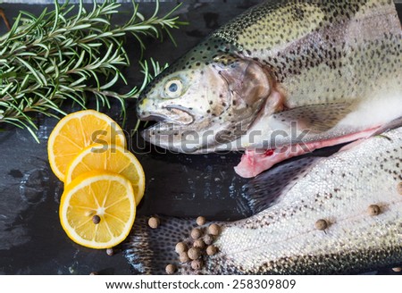 fresh  trout fish with spices on dark wooden table, preparation