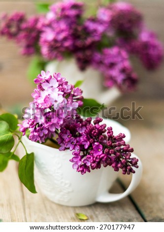 Herbal tea in a glass cup, a metal strainer with dry flowers marjoram, fresh flowers of oregano on the background of wooden boards