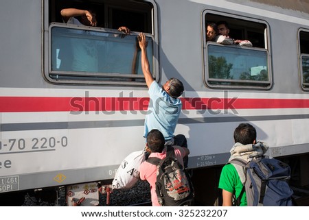 Tovarnik, Croatia - September 18, 2015: Refugees try to get on a train station in a village on the border between Serbia and Croatia