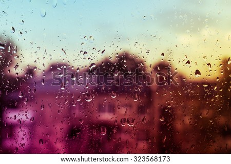 view from the window at the rain, thunder and lightning with drops on the glass