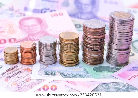 Stack of Thai coins on bank notes money background