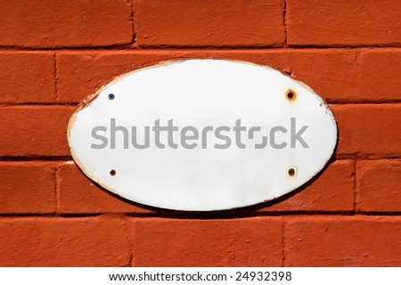 blank white sign on a colorful brick wall.
