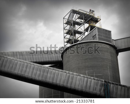 Factory silos against a grey, cloudy sky.