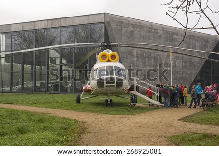 KRAKOW, POLAND - NOV 04, 2014: Aviation Museum in Krakow. Children\'s excursion group looks helicopter.