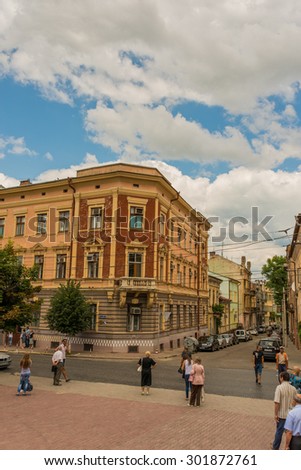 CHERNIVTSI, UKRAINE- JUL 25, 2015:  People are waiting for trolebus opposite the old dental clinic in Chernivtsi.  Architecture in the old town. Day off in the city center.
