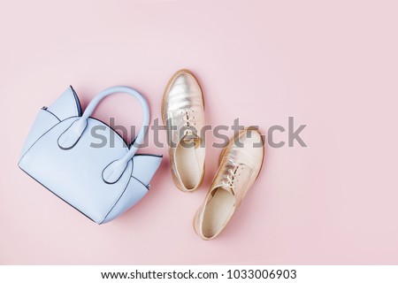 Cute blue ladies bag and stylish golden shoes. Flat lay, top view. Spring fashion concept in pastel colored