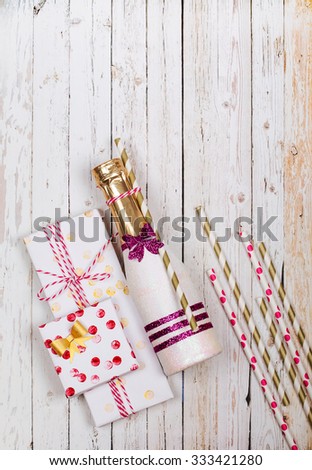 Beautified mini champagne and handmade gifts on a wooden background. View from above