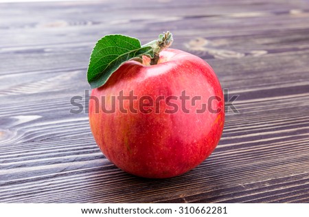 apple flowers and ripe red apples on a wooden background closeup