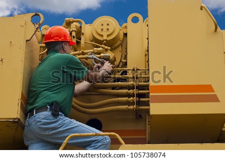 man doing maintenance work on a large piece of machinery