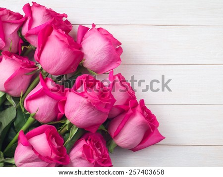 Pink roses bouquet on the white planks background