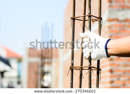 Safety a hand by white glove for working time of labor,workman with bundle bars,iron ready for construction.Focus on a white glove and iron in a hand