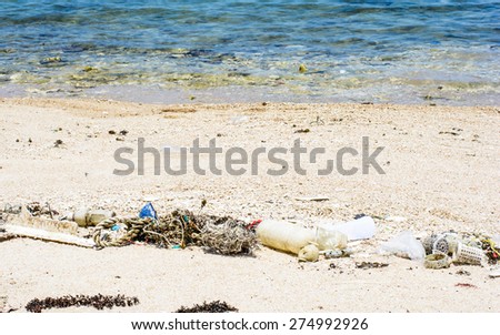 Many plastic and garbage is a pollution on the beach,Focus on garbage and blurry on water