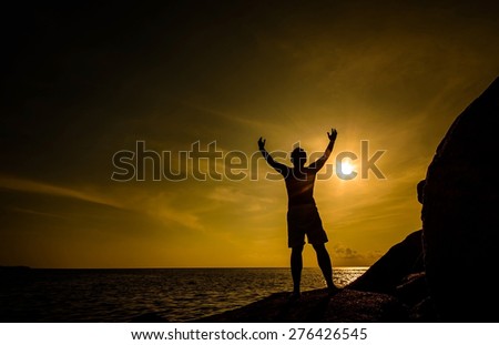 Time to relax  with silhouette of a man on beach after hard work and successful of job on sunset time,Focus on a man,Blurry and soft on water
