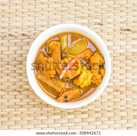 Hot and spicy with sour curry of thai tradition food put on a brown mat,Focus on sour curry in a bowl