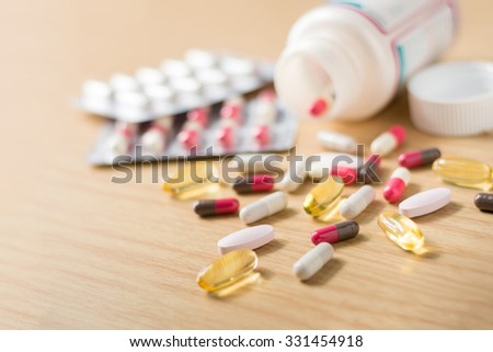Colorful tablets and dietary supplement cod liver oil with capsules and with panels drug spilling out of a bottle, healthcare and medicine medication cure