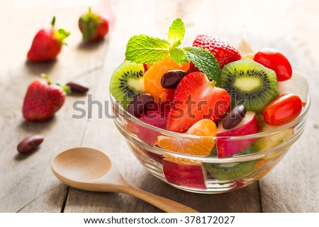 Diet-Fresh tasty mix fruit salad in the bowl on the wooden table, healthy breakfast, weight loss concept
