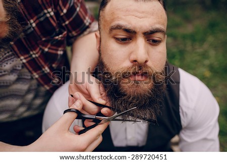 two bearded men shave outdors