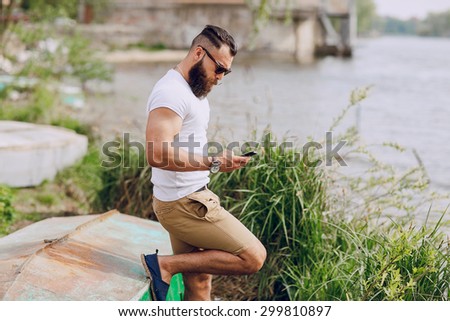 bearded man on the boat with phone