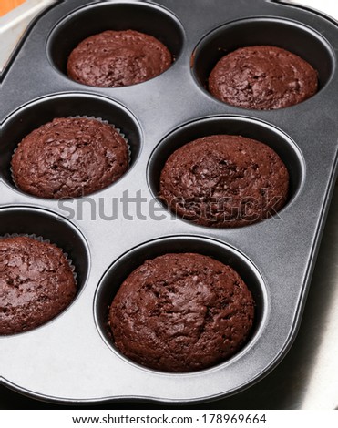 Homemade chocolate muffins in a baking tin