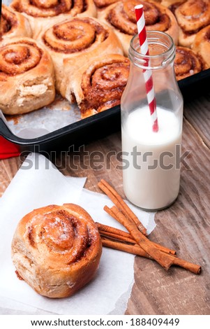 Milk in a bottle with paper straw and delicious  cinnamon bun