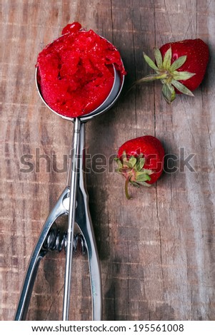 Scoop of strawberry sorbet on the wooden table