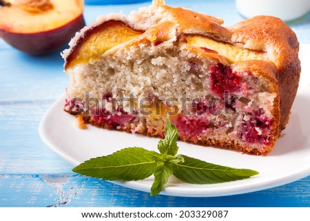 A piece of delicious pie with peaches and raspberry close-up