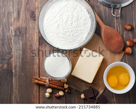 Ingredients and tools for baking sweet cake with chocolate and nuts, up view