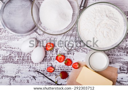 Ingredients for making strawberry yogurt cake on white wooden background, top view.