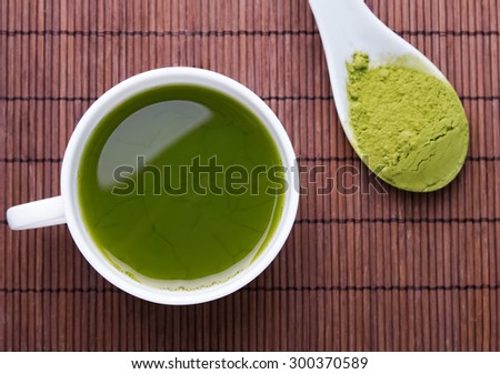 Matcha tea in a white cup on the brown mat, top view