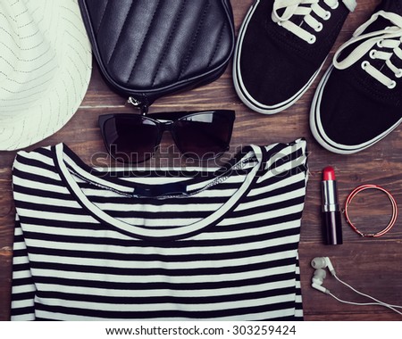 Modern girl outfit on wooden background, top view. Retro toned photo.