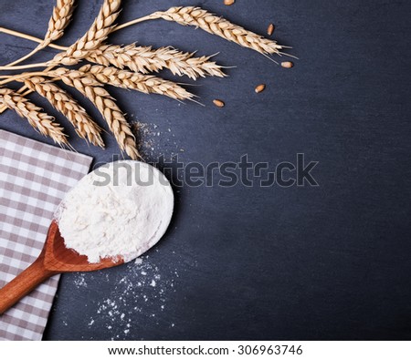 Flour and wheat on the black board, top view