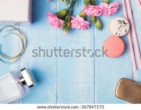 Cute feminine objects on blue colored table, top view