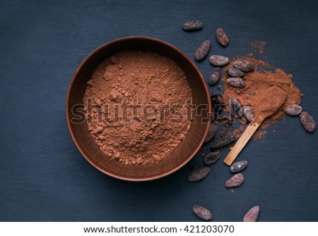 Cocoa powder in a bowl on the black background