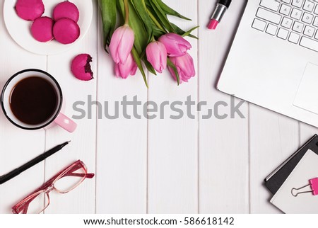 Woman\'s work place top view. Computer, glasses, coffee and accessories in pink color on white wooden table.