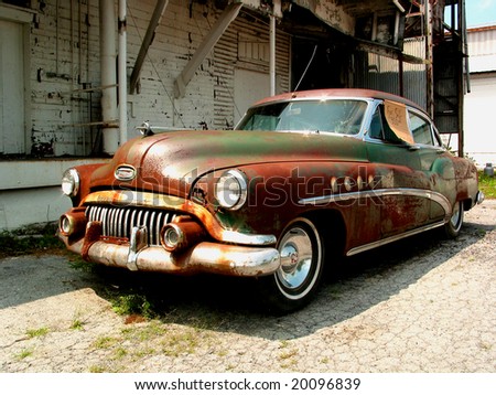 stock photo : Derelict vintage car with for sale sign in front of abandoned 
