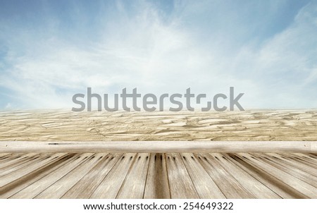 wood floor with foot stamp on sand beach and blur sky background ,summer concept