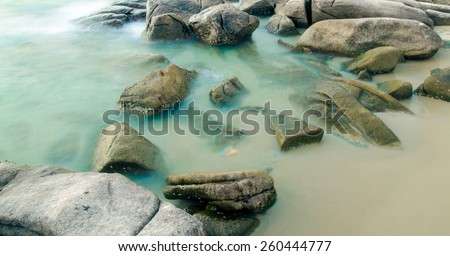 Long Exposure Seascape with running waves on the rocks at the beach trip at rayong : soft focus
