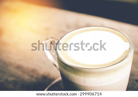 Cup of coffee on wooden table. with orange light  and vintage tone