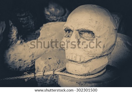 Ancient stone skull and rope Hanged naked