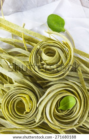 Raw homemade spinach pasta with spinach leaves